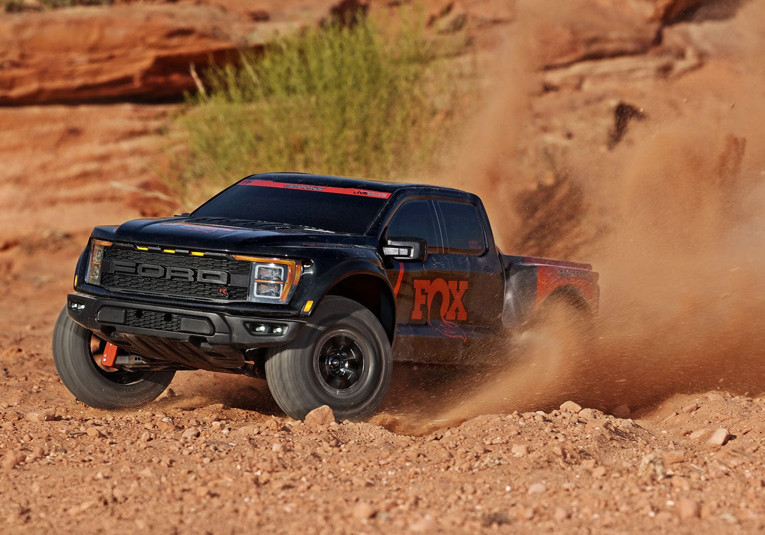[Action] Traxxas Raptor R - çölde drift yapan siyah-turuncu RC pickup