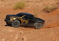 [Action] Traxxas Raptor R - kumlu arazide yan görünüm altın-siyah RC pickup