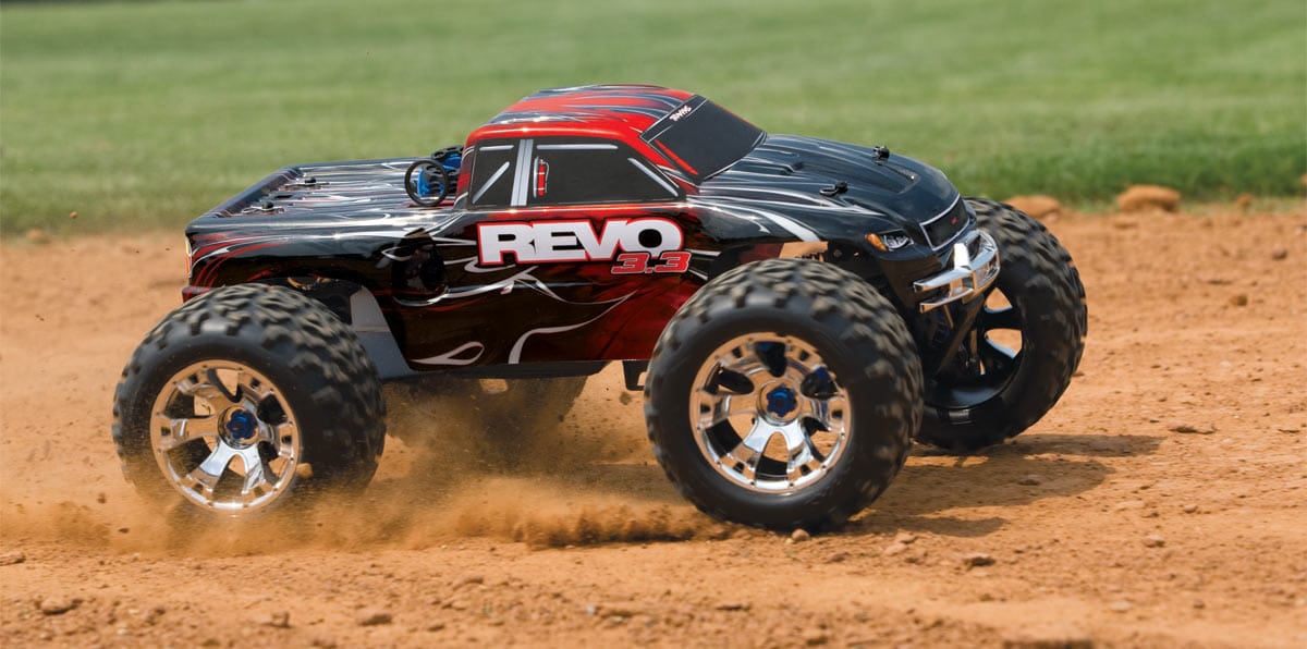 [Action] Traxxas Revo 3.3 - toprak zeminde toz kaldıran kırmızı monster truck yandan