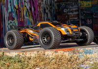 [Action] Traxxas XRT 4WD - turuncu araç grafitili duvar önünde bordür üstünde