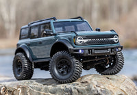 [Action] Traxxas TRX-4M Bronco - koyu yeşil araç kaya üzerinde arazi pozu