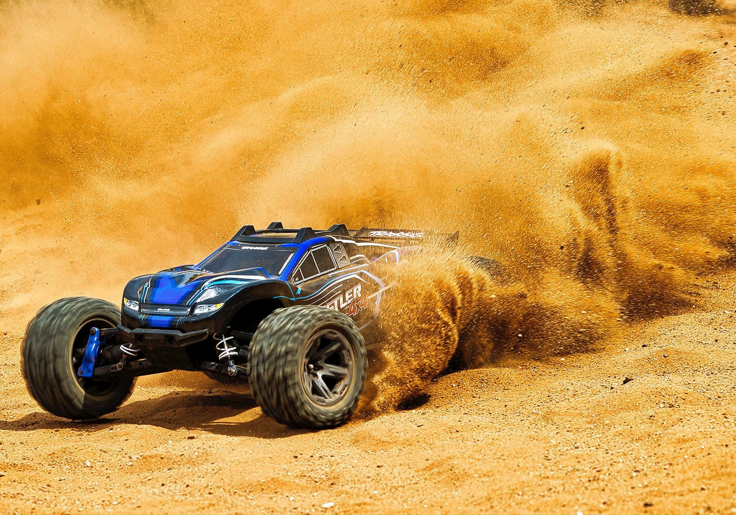 [Action] Traxxas Rustler Combo - mavi araç çölde toz kaldırırken yandan