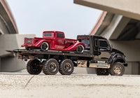 [Action] Traxxas TRX-6 Hauler - açık havada yandan, kırmızı hot rod taşırken üst geçit altında