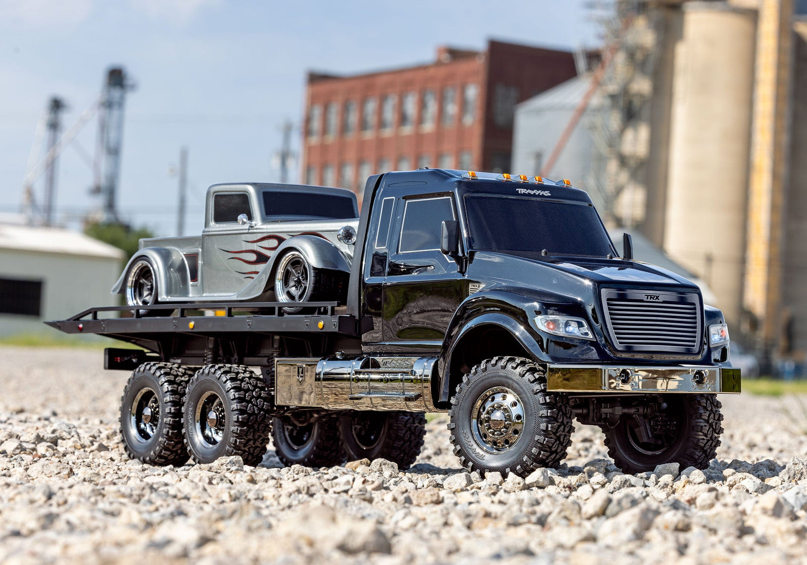 [Action] Traxxas TRX-6 Hauler - çakıl arazide, gümüş alev desenli hot rod yüklü