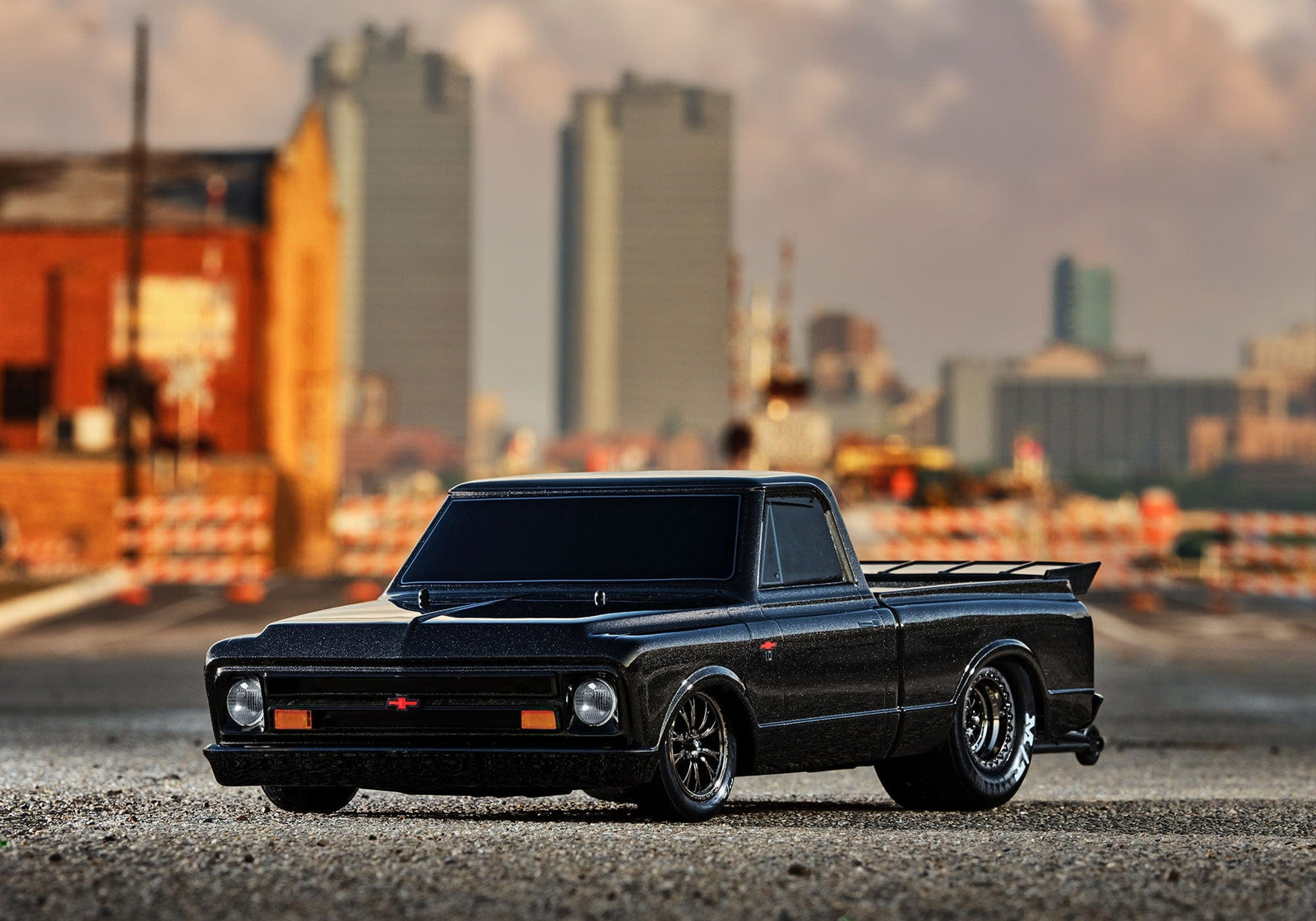 [Action] Traxxas Drag Slash - siyah araç önden, şehir silüeti arkaplanı