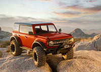 [Action] Traxxas Bronco Combo - kırmızı araç gün batımında kayalık arazide