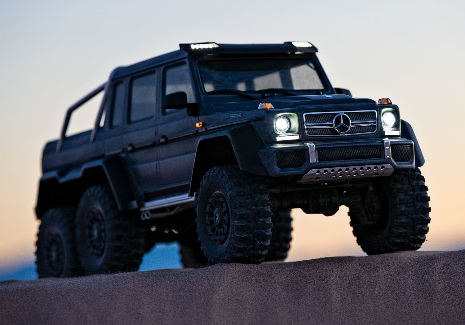 [Action] Traxxas G63 6x6 - gün batımında kum tepesinde, farlar açık