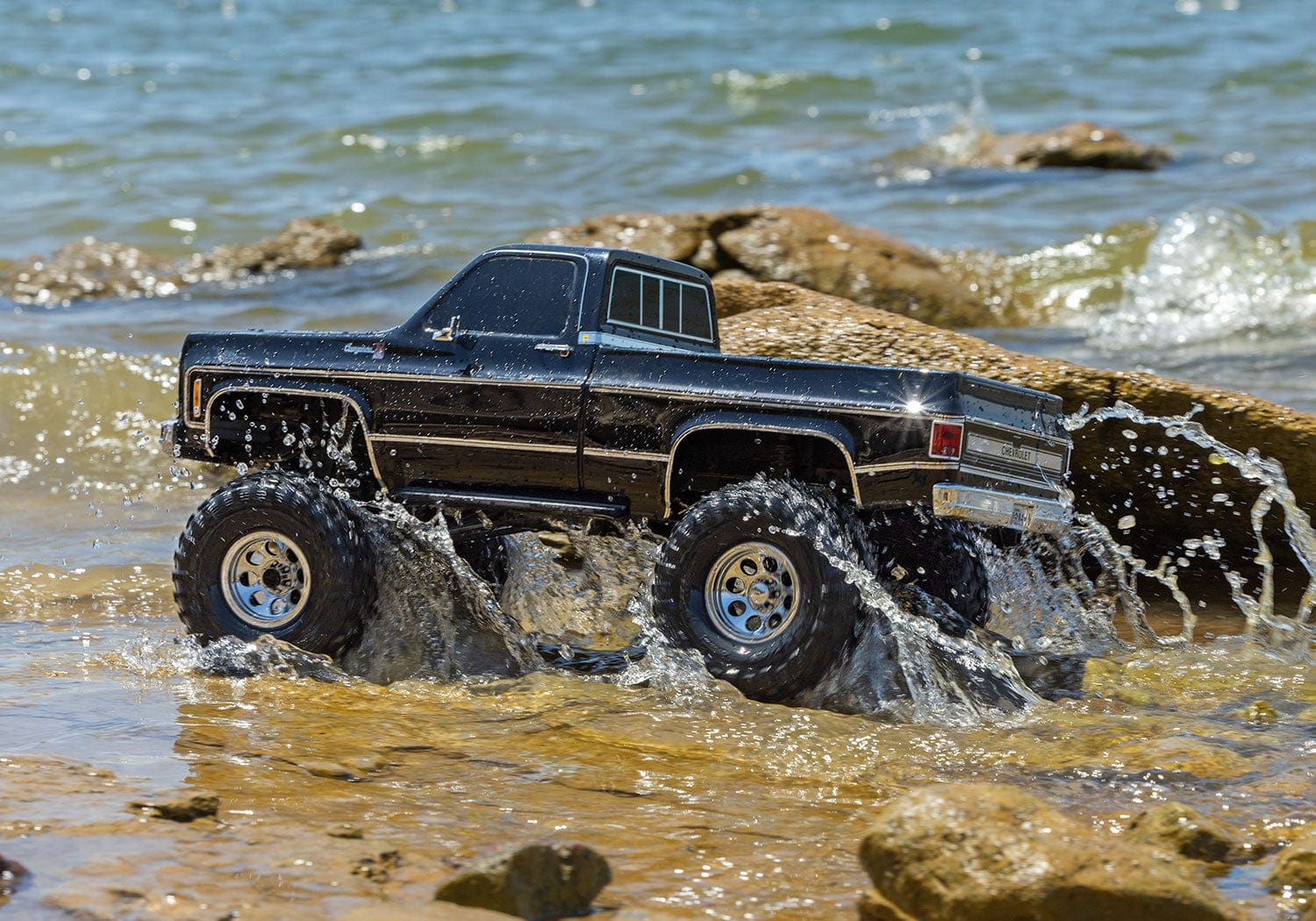 [Action] Traxxas K10 Cheyenne - siyah araç su ve kayalarda, arka çapraz görünüm